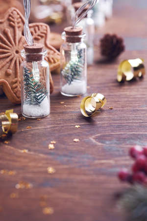 Christmas tree in glass jar garland decoration, Christmas fir tree branches and Christmas gingerbread on old wooden background. Selective focus, copy space. Merry Christmas and happy new year conceptの写真素材