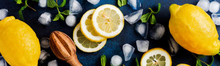 Two fresh lemons in dark blue plate on turquoise concrete background. Food background. Top view.の写真素材