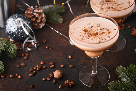 Alexander cocktail in cocktail glass on wooden table with shaker, nutmeg and small grater with...