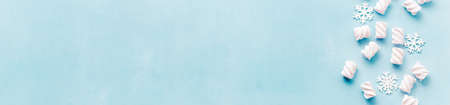 Christmas marshmallows and snowflakes on a blue concrete background.Top view.の写真素材