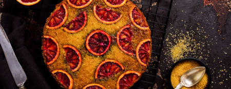 Upside down blood orange cake on old dark concrete background. Rustic stile. Selective focus