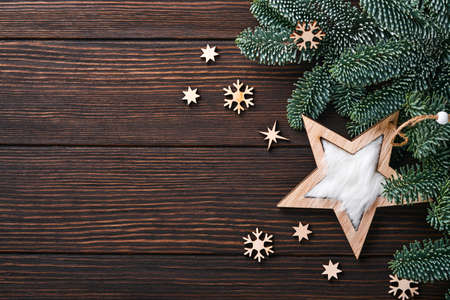 Christmas or New Year background with fir branches and wooden snowflakes and stars Christmas balls, gift box on dark wooden background. Place for your text. Christmas greeting card.の写真素材