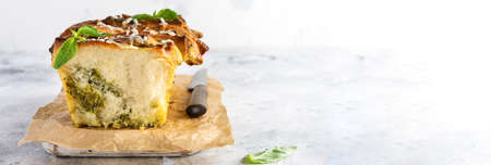 Pull-apart bread with Italian pasta pesto, basil and parmesan cheese in baking form over old light concrete background. Top view. Rustic stile.の写真素材