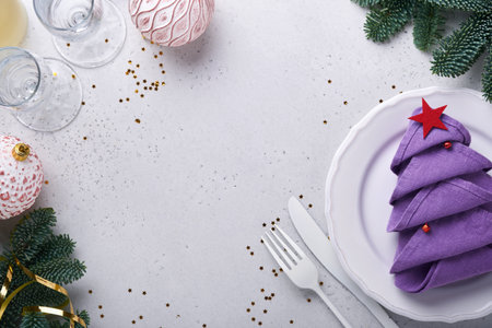 Christmas table setting white color with silverware, napkin folded as Christmas tree trendy color very peri in 2022 Year, Christmas balls, champagne, glasses on white background. Mock up.の写真素材