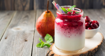Healthy breakfast. Fresh cranberry smoothie in a glass jar on the old wooden background. Selective focus.の写真素材