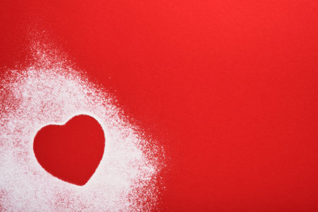 Heart shape frame made of flour on red background. Happy Valentines day, mothers day. Valentines day gift bakery concept for card or creative design. Top view.の写真素材