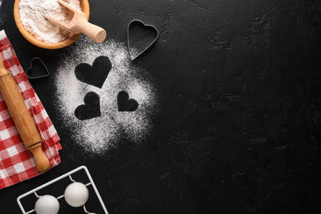 Valentines day baking background with heart shape, flour, tools and ingredients for cooking homemade...
