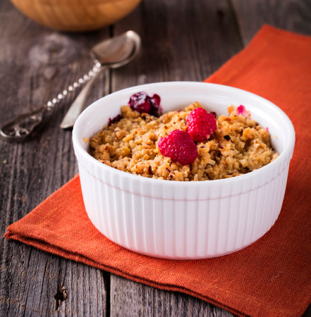 Plum and raspberry crumb on the old wooden background. Rustic style. Selective focus.の写真素材