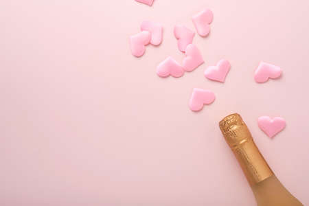 Valentines day greeting card with champagne bottle, tow glasses, chocolate hearts and gift box on...