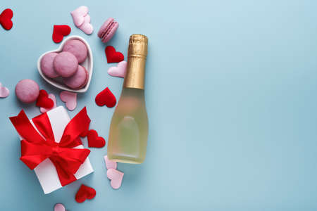 Valentines Day card. White gift boxes with red ribbon, champagne bottle and macaron macaroon cookie on blue background. 8 March, Womens Mothers Valentines Day, Birthday. Mock up.の写真素材