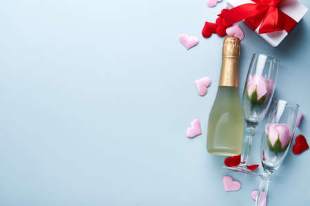 Valentines Day card. White gift boxes with red ribbon, champagne bottle and macaron macaroon cookie on blue background. 8 March, Womens Mothers Valentines Day, Birthday. Mock up.の写真素材