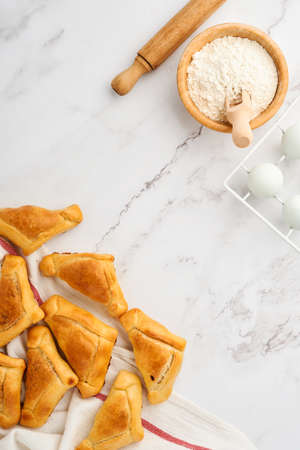 Fried empanadas with cilantro, meat, egg, tomato and chili sauce on white background. Latin American...