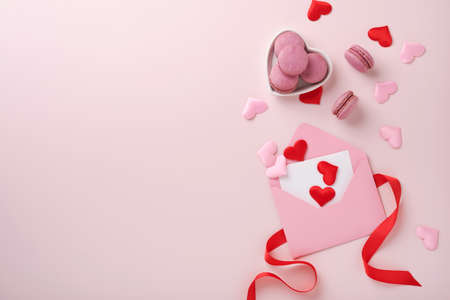 Valentine's day card. Pink empty envelope with blank white note mockup inside, macaron macaroon...