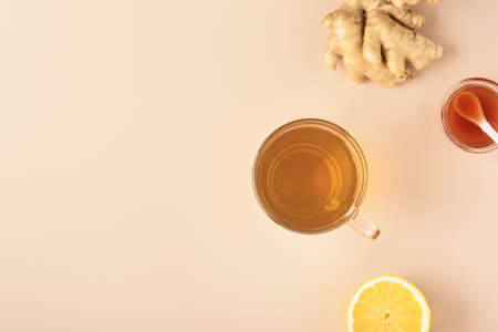 Ginger tea. Cup of ginger tea with lemon, honey and mint on beige background. Concept alternative medicine, natural homemade remedy for cold and flu. top view. Free space for your text.の写真素材