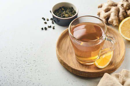 Ginger tea. Cup of ginger tea with lemon, honey and mint on gray background. Concept alternative medicine, natural homemade remedy for cold and flu. top view. Free space for your text.の写真素材