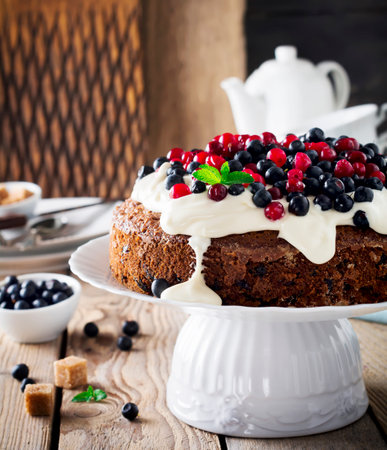 Cake with fresh berries and cream on old wooden background. selective focus.の写真素材