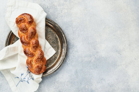 Sabbath kiddush ceremony composition. Challah bread. Freshly baked homemade braided challah bread for Shabbat and Holidays on light gray background, Shabbat Shalom. top view. copyspace.の写真素材