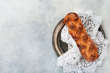 Sabbath kiddush ceremony composition. Challah bread. Freshly baked homemade braided challah bread for Shabbat and Holidays on light gray background, Shabbat Shalom. top view. copyspace.の写真素材