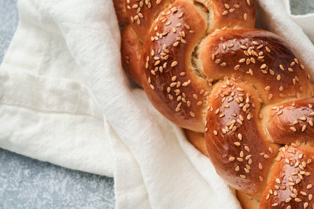 Sabbath kiddush ceremony composition. Challah bread. Freshly baked homemade braided challah bread for Shabbat and Holidays on light gray background, Shabbat Shalom. top view. copyspace.の写真素材