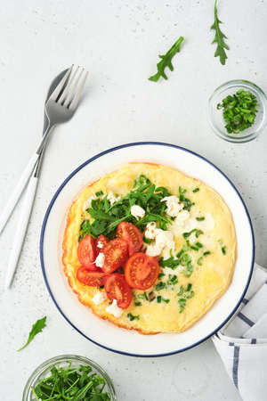 Breakfast fried eggs. Rustic omelette or frittatas with green onions, cheese mozzarella, green...
