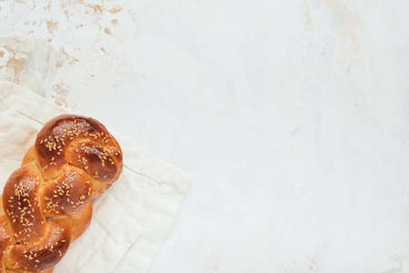 Challah bread. Sabbath kiddush ceremony composition. Freshly baked homemade braided challah bread for Shabbat and Holidays on white background, Shabbat Shalom. top view. copyspace.の写真素材