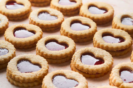 Traditional Linzer cookie with strawberry jam and powder sugar on pink beautiful background. top...