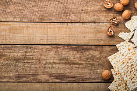 Matzah, red kosher and walnut. Traditional ritual Jewish bread on old wooden rustic background. Passover food. Pesach Jewish holiday of Passover celebration concept.の写真素材