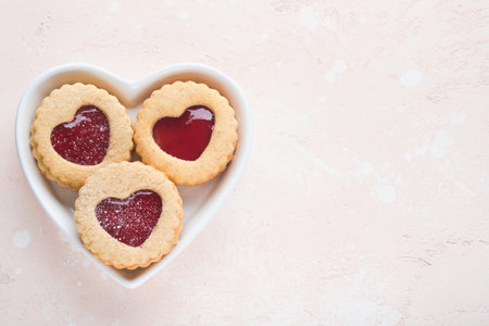 Traditional Linzer cookie with strawberry jam and powder sugar on pink beautiful background. top view. Traditional homemade Austrian sweet dessert food on Valentines Day. Holiday snack concept.の写真素材