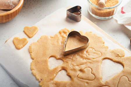 Baking ingredients and kitchen utensils on a white background top view. Preparing heart sugar cookies. Baking background. Flour, eggs, sugar, spices, and a whisk on the kitchen table. flat lay.の写真素材
