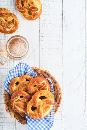 Bavarian pretzels and glass of lager beer. Oktoberfest food menu, traditional salted pretzels over old white wooden background. Top view with space for text. Oktoberfest themeの写真素材