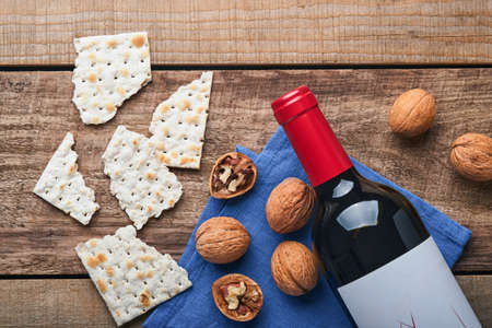 Matzah, red kosher and walnut. Traditional ritual Jewish bread on old wooden rustic background. Passover food. Pesach Jewish holiday of Passover celebration concept.の写真素材
