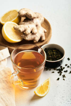 Ginger tea. Cup of ginger tea with lemon, honey and mint on gray background. Concept alternative medicine, natural homemade remedy for cold and flu. top view. Free space for your text.の写真素材