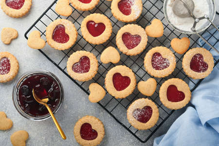 Traditional Linzer cookie with strawberry jam and powder sugar on light gray beautiful background. top view. Traditional homemade Austrian sweet dessert food on Valentines Day. Holiday snack concept.の写真素材