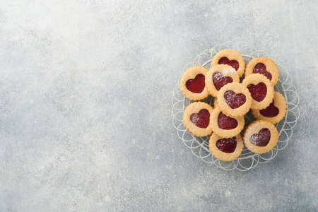 Traditional Linzer cookie with strawberry jam and powder sugar on light gray beautiful background. top view. Traditional homemade Austrian sweet dessert food on Valentines Day. Holiday snack concept.の写真素材