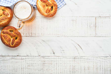 Bavarian pretzels and glass of lager beer. Oktoberfest food menu, traditional salted pretzels over old white wooden background. Top view with space for text. Oktoberfest themeの写真素材