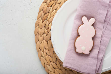 Easter table setting. Easter dinner with white bunny, fresh spring flowers and eggs. Elegance pastel and pink tablescapes. view from above. Christian religion tradition. Happy Easter concept. Mock up.の写真素材