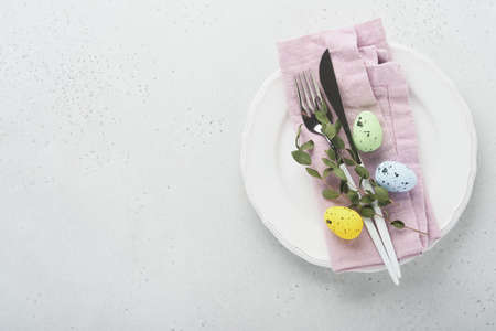 Easter table setting. Easter dinner with multicolored easter eggs. Elegance pastel and pink tablescapes. view from above. Christian religion tradition. Happy Easter concept. Mock up.の写真素材