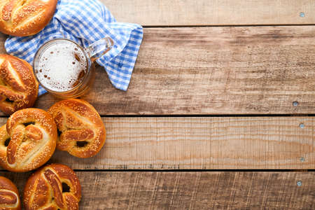 Bavarian pretzels and glass of lager beer. Oktoberfest food menu, traditional salted pretzels over old wooden background. Top view with space for text. Oktoberfest themeの写真素材