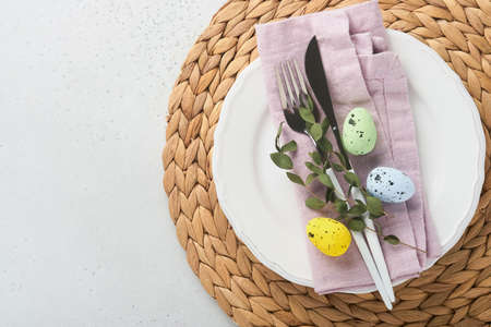 Easter table setting. Easter dinner with multicolored easter eggs. Elegance pastel and pink...