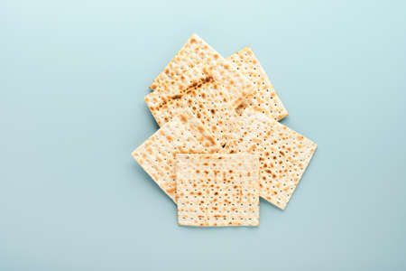 Passover celebration concept. Matzah, red kosher and walnut. Traditional ritual Jewish bread on blue...