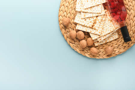 Passover celebration concept. Matzah, red kosher and walnut. Traditional ritual Jewish bread on blue...