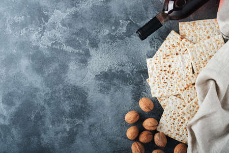 Passover celebration concept. Matzah, red kosher and walnut. Traditional ritual Jewish bread on old...