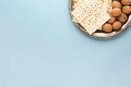 Passover celebration concept. Matzah, red kosher and walnut. Traditional ritual Jewish bread on blue background. Passover food. Pesach Jewish holiday.の写真素材