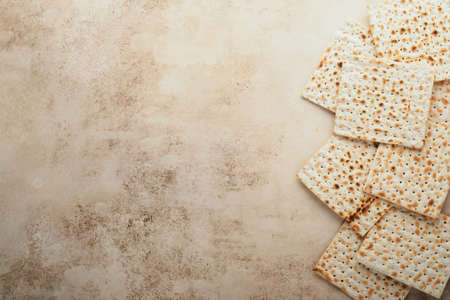 Passover celebration concept. Matzah, red kosher and walnut. Traditional ritual Jewish bread on sand...