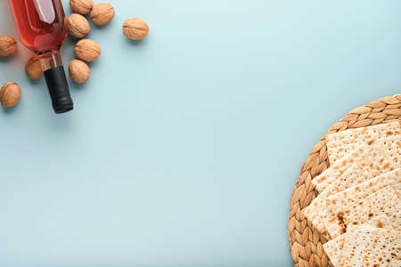 Passover celebration concept. Matzah, red kosher and walnut. Traditional ritual Jewish bread on blue...
