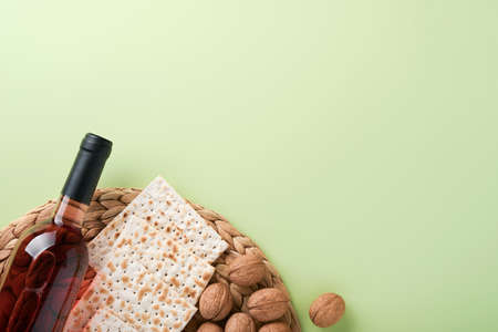 Passover celebration concept. Matzah, red kosher and walnut. Traditional ritual Jewish bread on light green monochrome background. Spring. Passover food. Pesach Jewish holiday.の写真素材