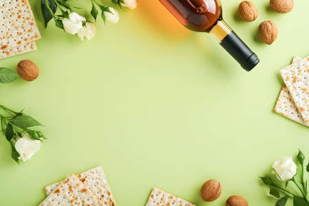 Passover celebration concept. Matzah, red kosher wine, walnut and spring beautiful rose flowers....