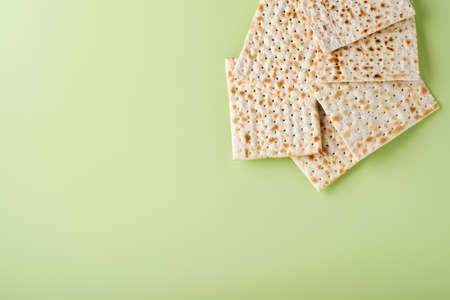 Matzah, red kosher and walnut. Passover celebration concept. Traditional ritual Jewish bread on light green background. Passover food. Pesach Jewish holiday.の写真素材