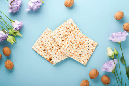 Pesach Jewish holiday. Passover celebration concept. Matzah, red kosher wine and walnut. Traditional ritual Jewish bread on light blue background. Passover food.の写真素材