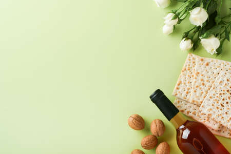 Passover celebration concept. Matzah, red kosher wine, walnut and spring beautiful rose flowers....